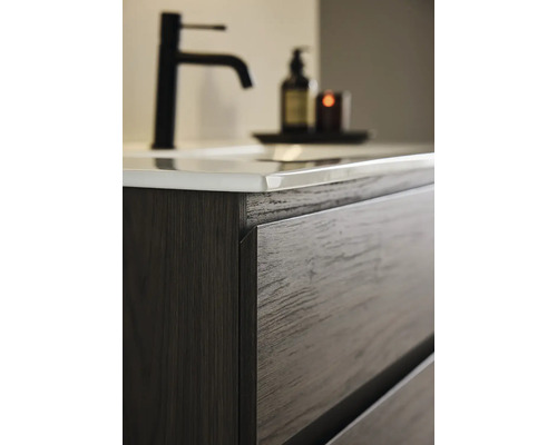 Detaljbild av ett tvättställsskåp med lådor och handfat