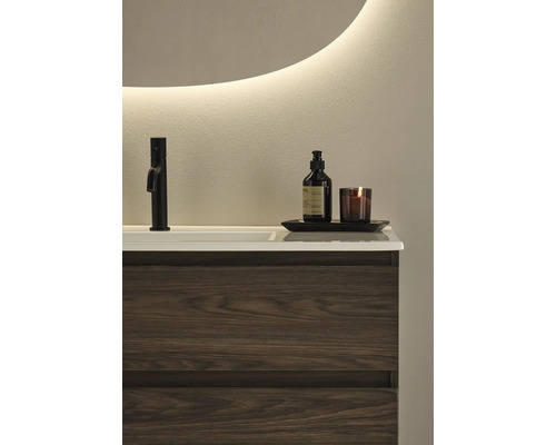 Badrum med handfat, kran, tvålpump och ljus