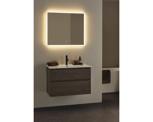 Badrum med tvättställsskåp, tvättställsskål, blandare och upplyst spegel