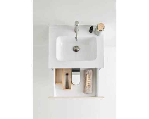 Tvättställ med öppen låda som innehåller badrumsartiklar