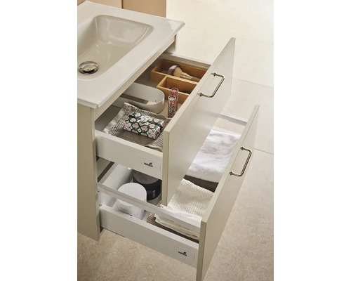 Tvättställsskåp med öppna lådor och badrumsartiklar