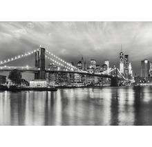 Svartvit bild av Brooklyn Bridge och New Yorks skyline på natten