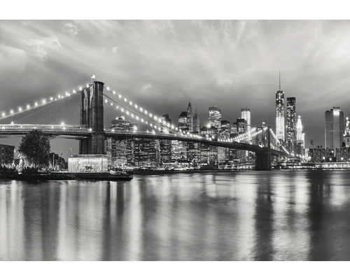 Svartvit bild av Brooklyn Bridge och New Yorks skyline på natten