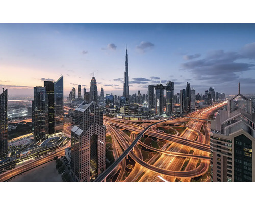 Silhuett av Dubai med skyskrapor och upplysta motorvägar i skymningen