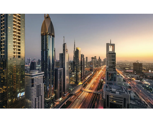 Panoramabild av Dubais skyline med upplysta skyskrapor och vägtrafik i skymningen.
