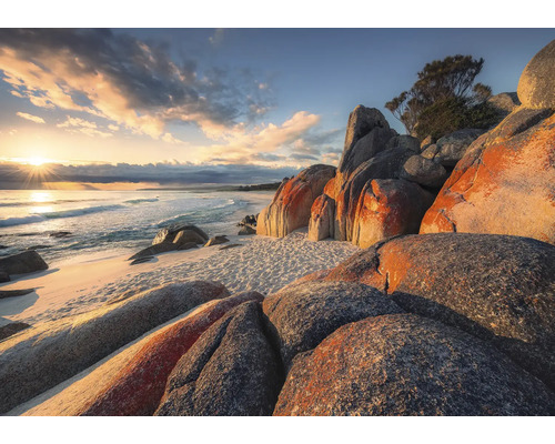 Sandstrand med klippor och havsutsikt vid soluppgång