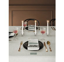 Dekorerat matbord med porslin, glas, bestick och ljus.