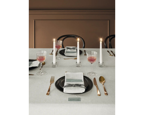 Dekorerat matbord med porslin, glas, bestick och ljus.