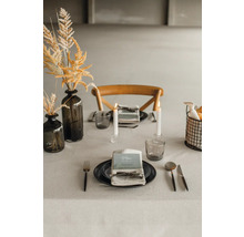 Dekorerat matbord med porslin, glas, ljus och blomvas