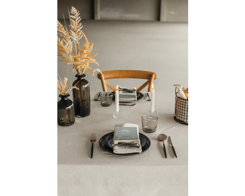 Dekorerat matbord med porslin, glas, ljus och blomvas