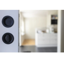 Detaljvy av skjutdörr med skålhandtag och vridknapplås