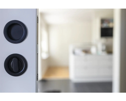 Detaljvy av skjutdörr med skålhandtag och vridknapplås