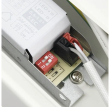 Detaljvy av en elektronisk komponent med strömbrytare och kabelanslutningar