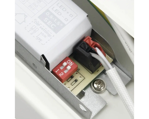 Detaljvy av en elektronisk komponent med strömbrytare och kabelanslutningar