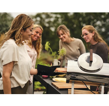 Kvinnor förbereder mat på en utomhusgrill.