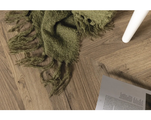 Dekorativ scen med trägolv, bok och grön filt