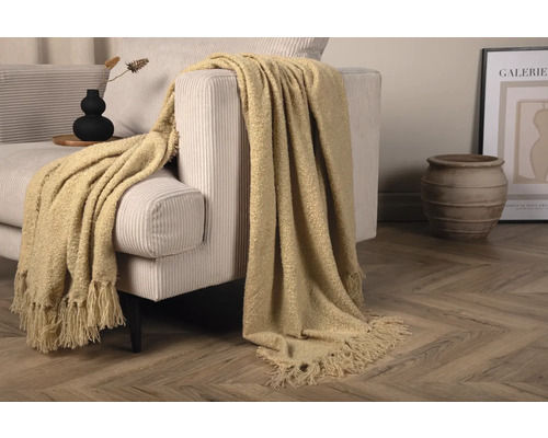 Dekorativt vardagsrum med beige soffa och beige överkast med fransar
