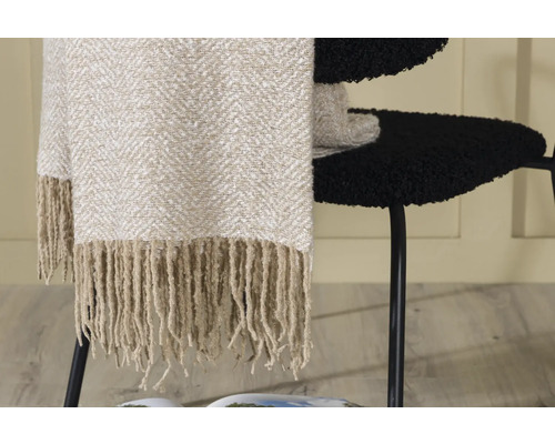 Beige filt med fransar på en svart stol