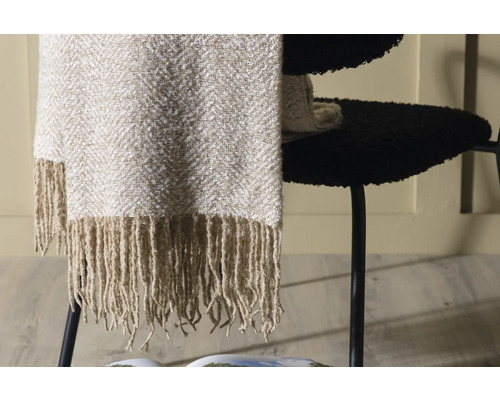 Dekorativ filt med fransar på en stol