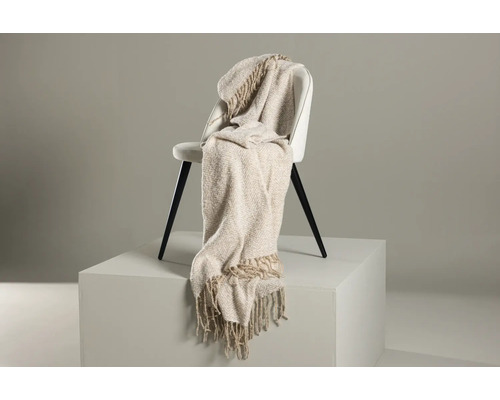 Beige överkast med fransar på en stol