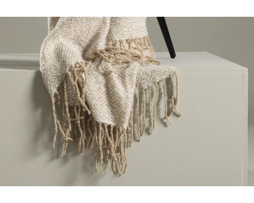 Dekorativ överkast med fransar på ett bord