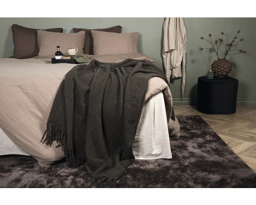 Sovrum med säng, filt och matta för en mysig atmosfär