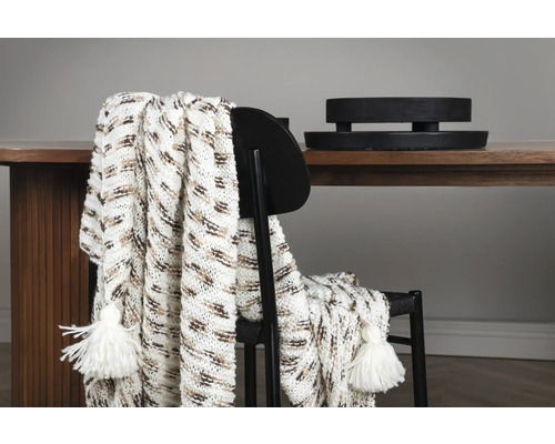 Mönstrad pläd med tofsar på en stol