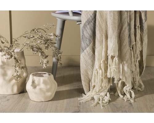 Dekorativ scen med två vaser, en filt med fransar och en stol