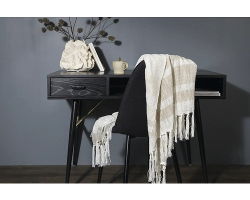 Skrivbord med dekorationer och en stol med en filt