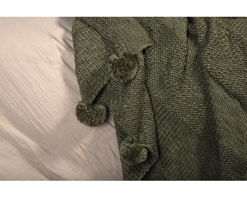 Grön stickad filt med tofsar