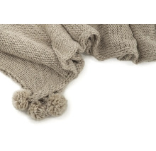 Beige stickad filt med tofsar