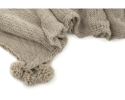 Beige stickad filt med tofsar