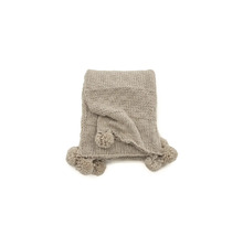 Beige stickad filt med tofsar