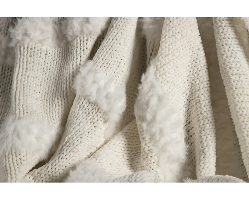 Närbild av en stickad filt med applikationer av fuskpäls