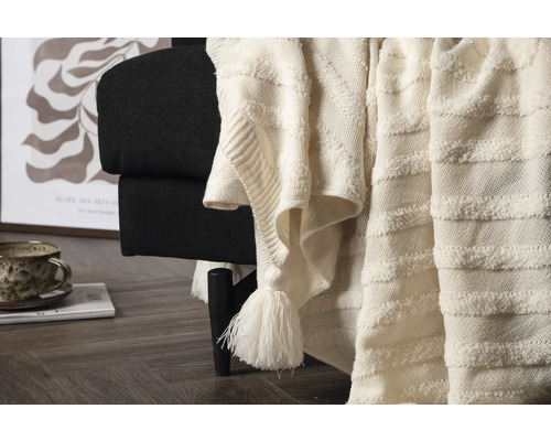 Dekorativ filt med fransar på en svart fåtölj