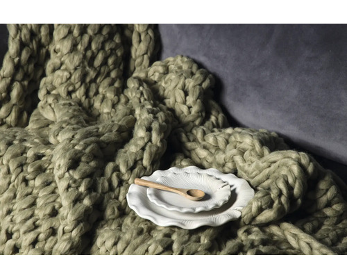 Dekorativ scen med grovstickad filt, keramikplattor och träsked