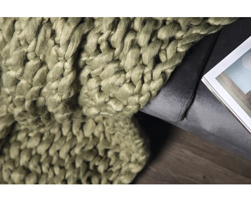 Grovstickad filt på en grå fåtölj