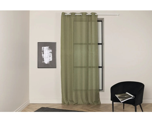 Vardagsrum med fönster, gardin och fåtölj