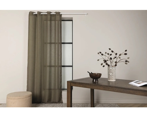 Miljöbild med gardin, bord och dekoration i ett rum