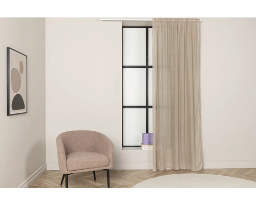 Vardagsrum med fåtölj, gardin och konstverk