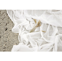 Dekorativt arrangemang med matta, lätt tyg och veteax