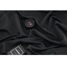 Ljus med två vekar på mörkt tyg och en bok