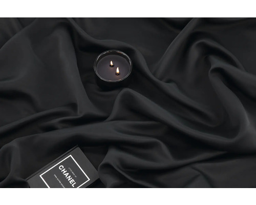 Ljus med två vekar på mörkt tyg och en bok