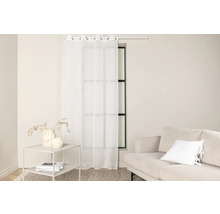 Ljust vardagsrum med fönster, gardin, bord och soffa