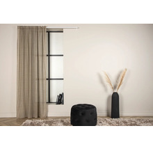 Vardagsrum med gardin, fönster, pall och vas på en matta.