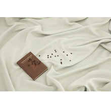 En bok med titeln 'Konsten att göra kaffe' ligger på en tygduk, omgiven av kaffebönor.