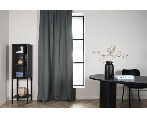 Vardagsrum med gardin, bord och vitrinskåp