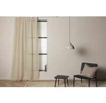 Vardagsrum med gardin, lampa, stol och bord på en matta