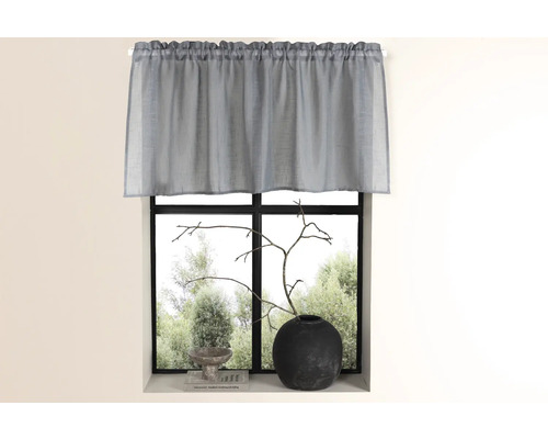 Gardin framför ett fönster med dekoration