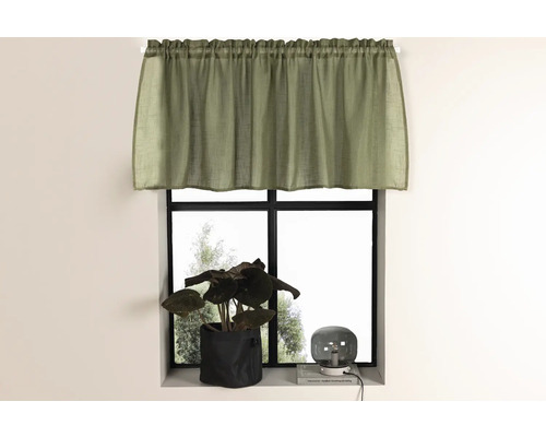 Gardin framför ett fönster med krukväxt och lampa